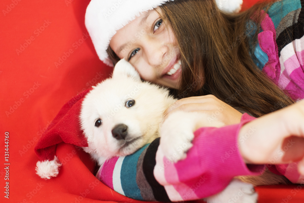 child and puppy in Christmas hat child and puppy in Christmas hat