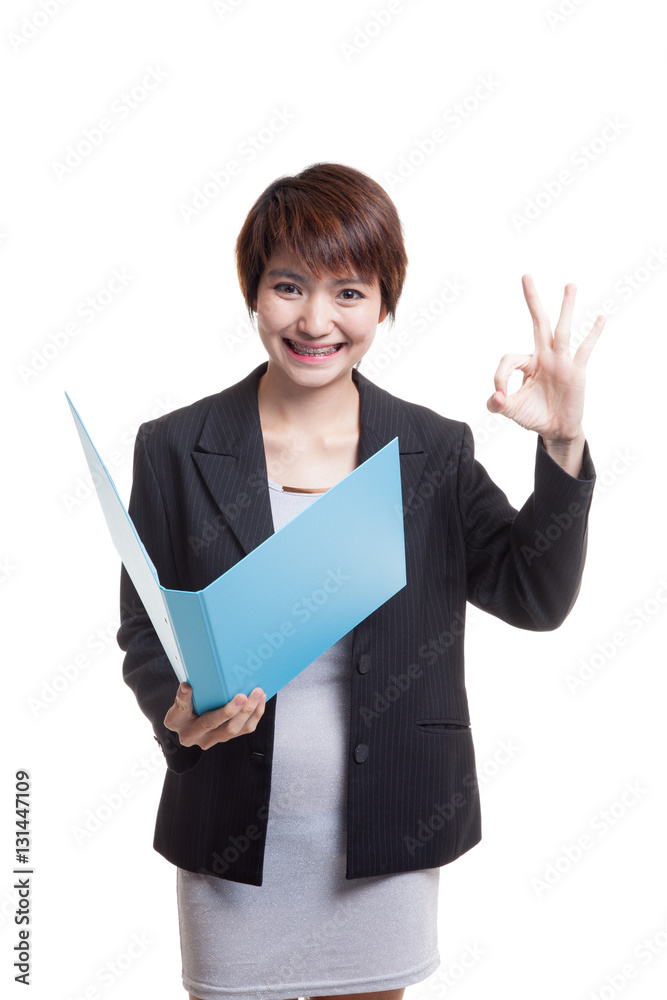 Young Asian working woman show OK with folder. Young Asian working woman show OK with folder.