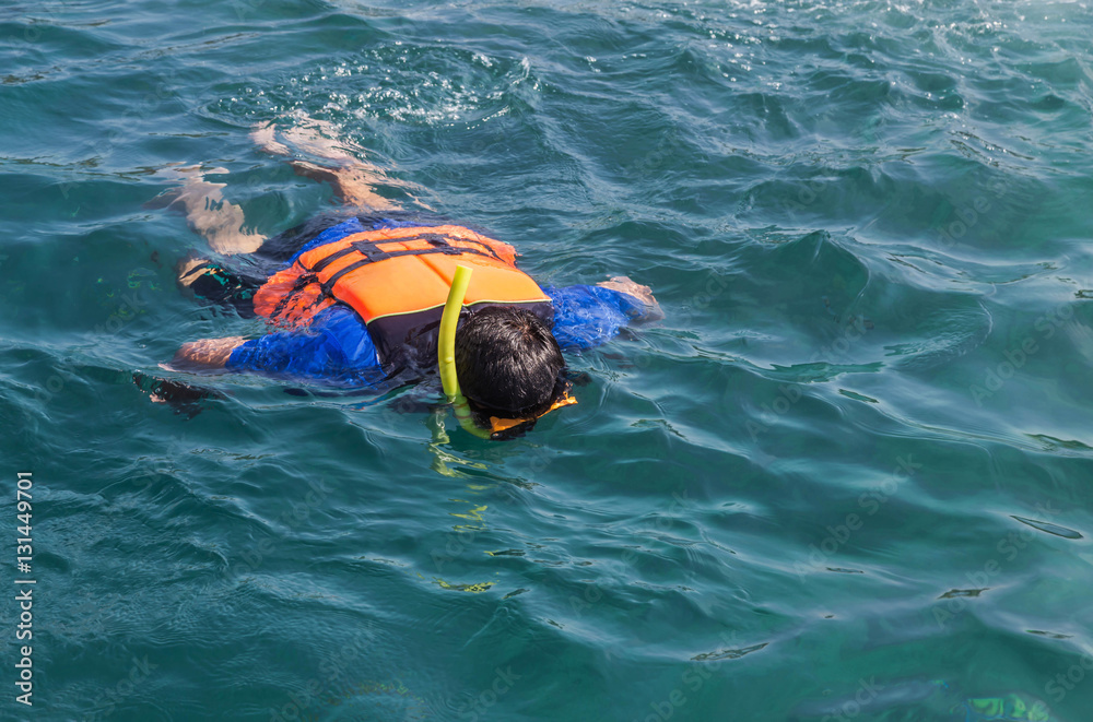 the man snorkeling with life jackets in andaman sea at phi phi islands, Thailand
