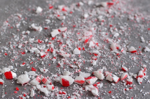 Crushed peppermint candy cane bits sprinkled on wax paper background