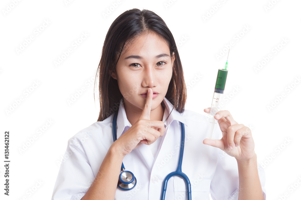 young Asian female doctor with syringe show quiet sign. young Asian female doctor with syringe show quiet sign.