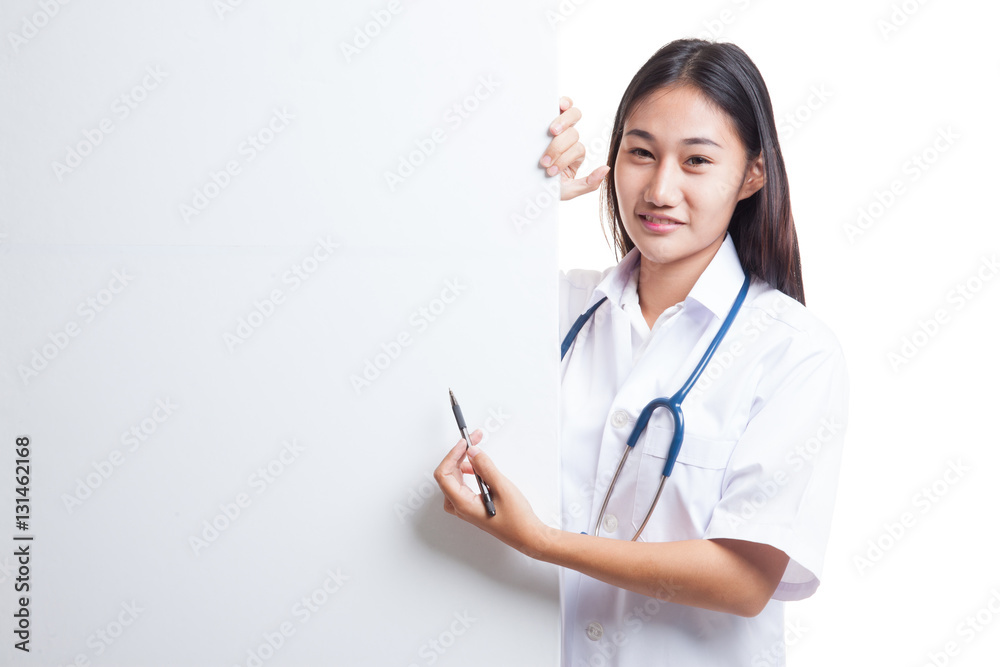 Young Asian female doctor peeking from behind blank sign point w Young Asian female doctor peeking from behind blank sign point w