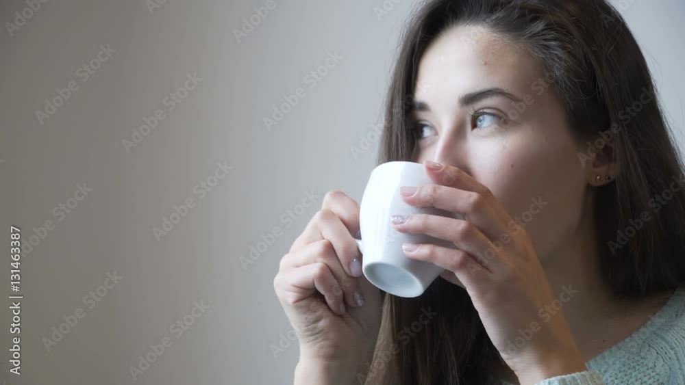 Beautiful girl drinking tea nera window. Portrait close-up. Beautiful girl drinking tea nera window. Portrait close-up.