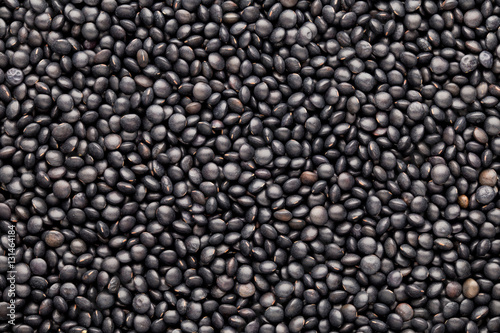 Food and cookery background of healthy dried black lentils.
