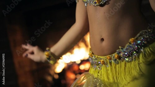 Woman in a yellow dress on a background of fire dancing belly dance.