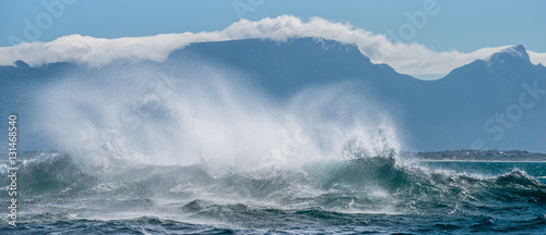 Seascape.  Clouds sky, waves with splashes, mountains silhouettes. False bay. South Africa. © Uryadnikov Sergey