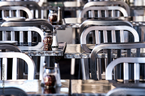 meal tables and chairs with salt and pepper shakers at outdoor restaurant