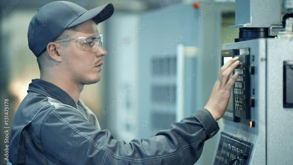 Industrial engineer worker operating control panel system at manufacture plant Industrial engineer worker operating control panel system at manufacture plant