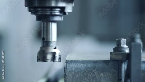 CNC milling machine produces metal detail on factory photo