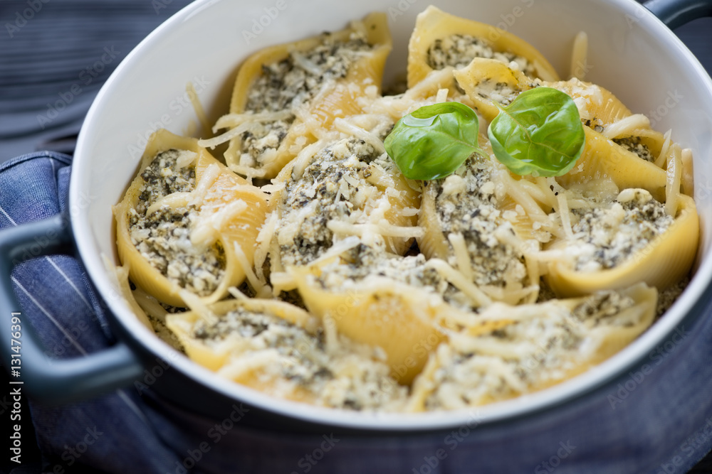 Close-up of a casserole with spinach and cheese conchiglione Close-up of a casserole with spinach and cheese conchiglione