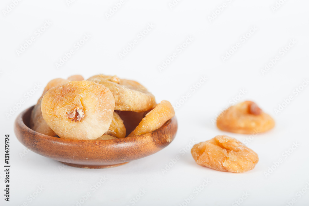 Dried figs in wooden bowl on white background Dried figs in wooden bowl on white background