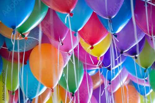 festive, colorful balloons with helium attachment to the white ribbons photo