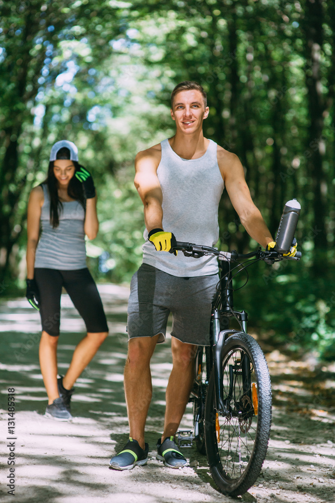 Young Couple Riding Bike In Park