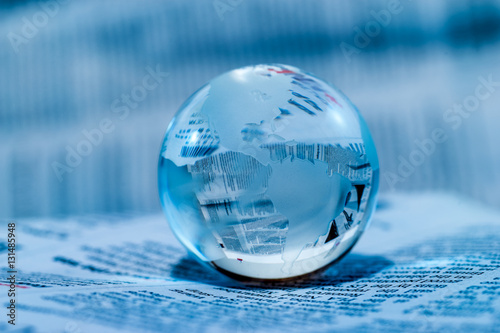 Glass Globe Against Newspaper