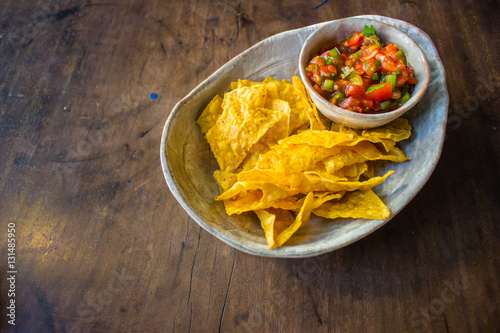 Salsa and chips on wooden table