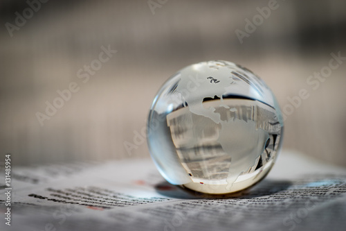 Glass Globe Against Newspaper