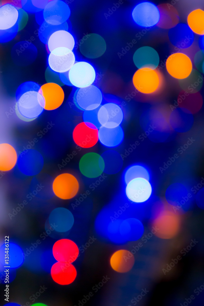 Fototapeta Blurry abstract colorful background. Colored Christmas garland. Bokeh and defocusing of the lens