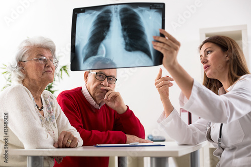 Doctor shows results to old patient x-ray of the lungs