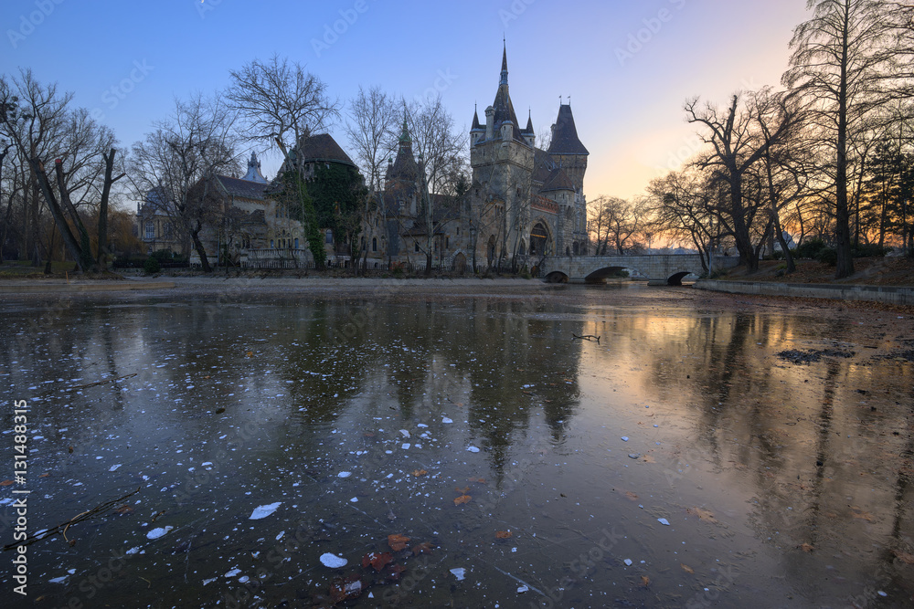 The reflection of Vajdahunyad Castle on the frozen lake at Budapest, Hungary during evening in cold winter season