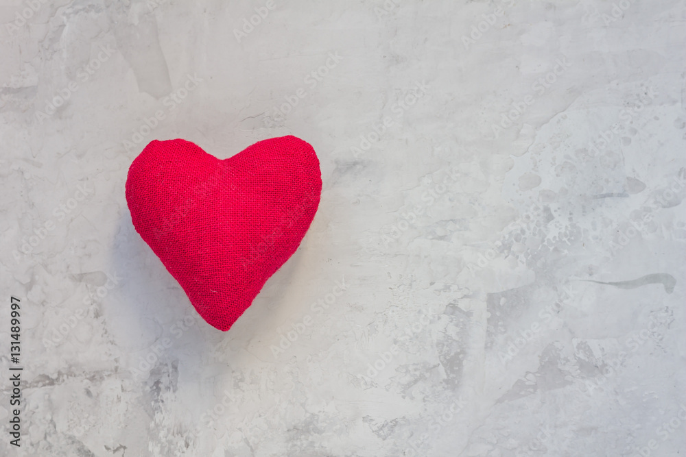 Handmade textile red heart on gray concrete background