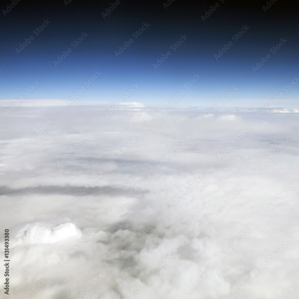 Above the clouds high in the sky. A view of the sky during the flight. Aircraft in the blue sky - the horizon of the atmosphere.