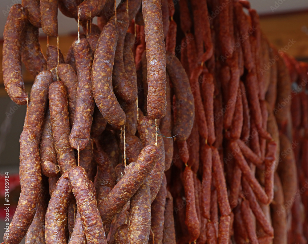 Cured smoked red meat sausages hanging in store Cured smoked red meat sausages hanging in store