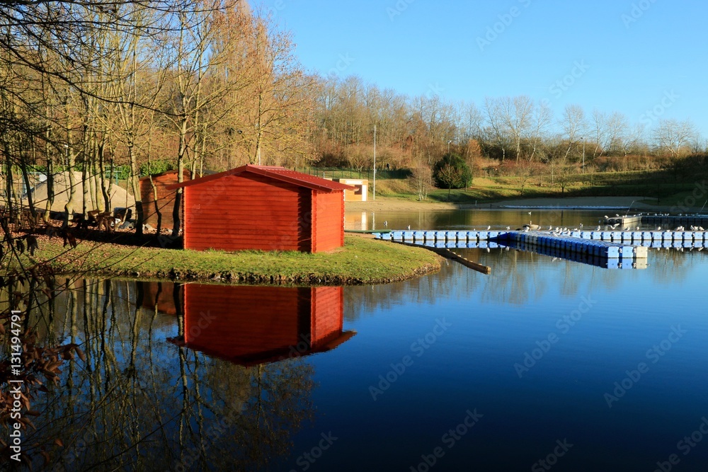 Obraz premium reflection of a wooden hut in the pond , park of Avion , Pas de Calais , hauts de France , France in winter , december 2016