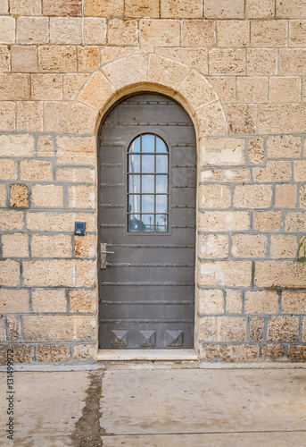 Vintage door with metal belts and rivets and barred window, Stella Maris Monastery in Haifa © alefbet26