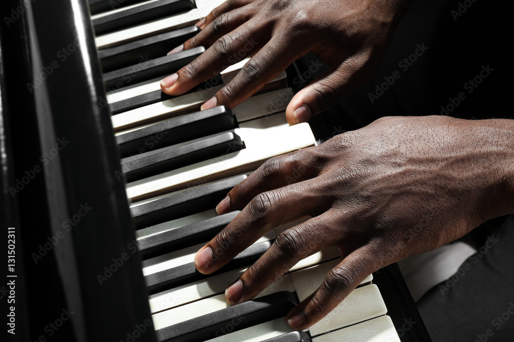 Naklejka premium Afro American man hands playing piano