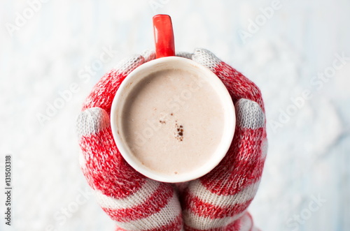 female hands in gloves holding hot chocolate