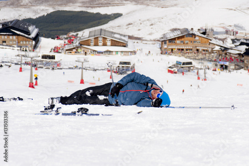 man lying on cold snow after ski crash at Sierra Nevada resort in Spain with mountains