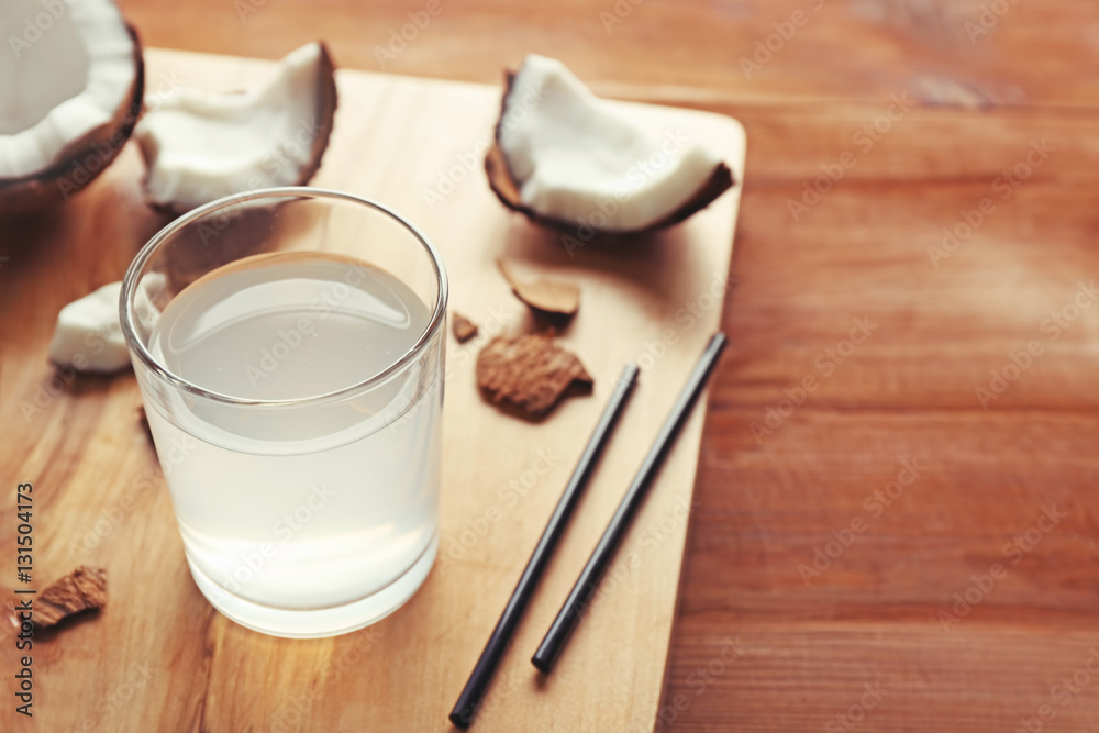Glass of coconut water and fresh nuts on wooden board Glass of coconut water and fresh nuts on wooden board