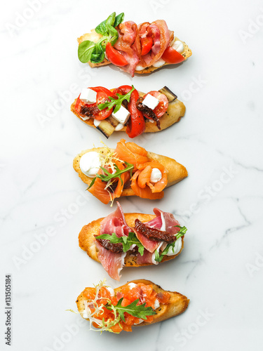 Different appetizers with fish, vegetables and fruits on marble