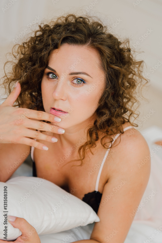 Sexy woman in bed in the morning showing her beautiful body. She doesn't wants to wake up. Awaken with natural light in her bedroom and covered with the bed sheets. Sexy woman in bed in the morning showing her beautiful body. She doesn't wants to wake up. Awaken with natural light in her bedroom and covered with the bed sheets.