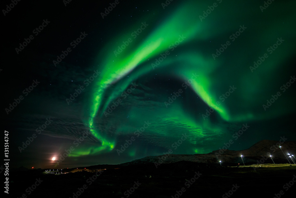 Northern lights and the rising Moon nearby Nuuk city, Greenland