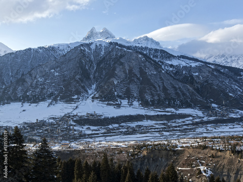 Winter in Greater Caucasus Mountains. Georgia (country). Mestia ski resort. Panoramic view from ski slope on snow mt. Ushba in sun winter day. Svaneti (Svanetia) region of Georgia. © phototravelua