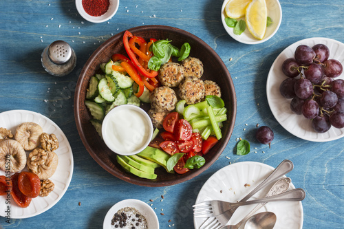Vegetarian snack table - quinoa meatballs, fresh raw vegetables, grapes, dried fruits on wooden table, top view. Flat lay