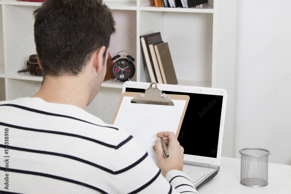 Fototapeta premium young man studying or working in the home or office with laptop computer