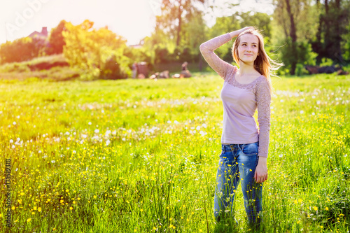 young woman walking in a meadow with yellow wildflowers