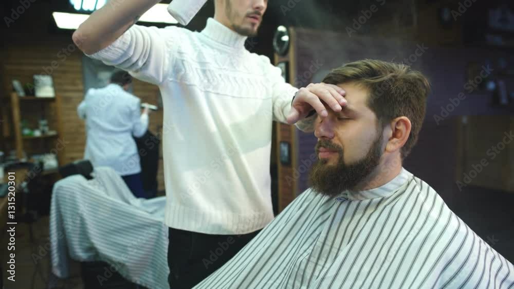 Confident man visiting hairstylist in barber shop. Confident man visiting hairstylist in barber shop.