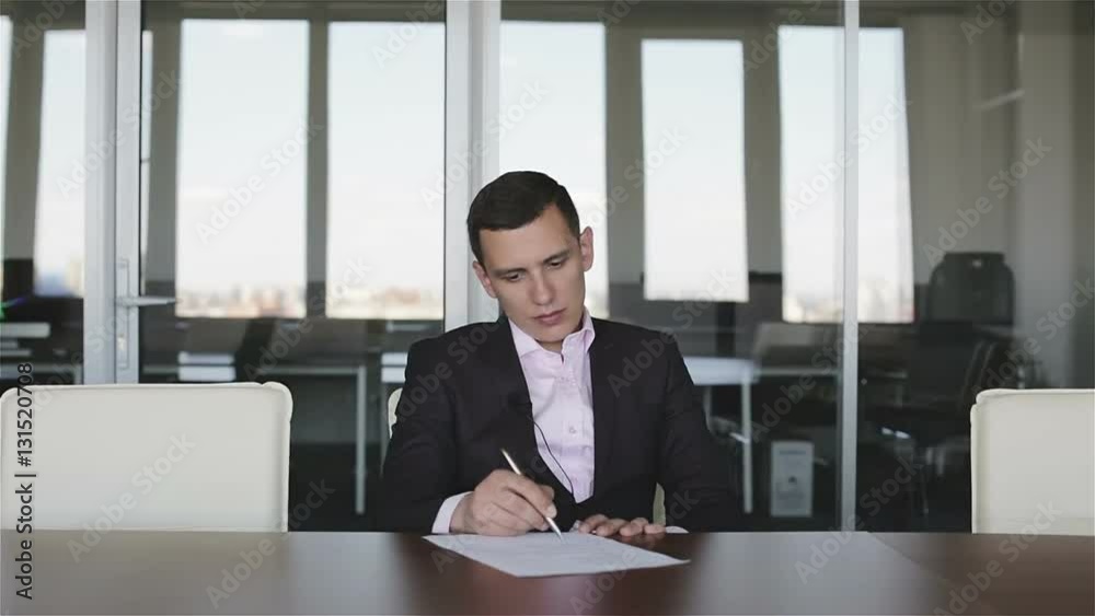 Serious businessman working in the office with documents. Serious businessman working in the office with documents.