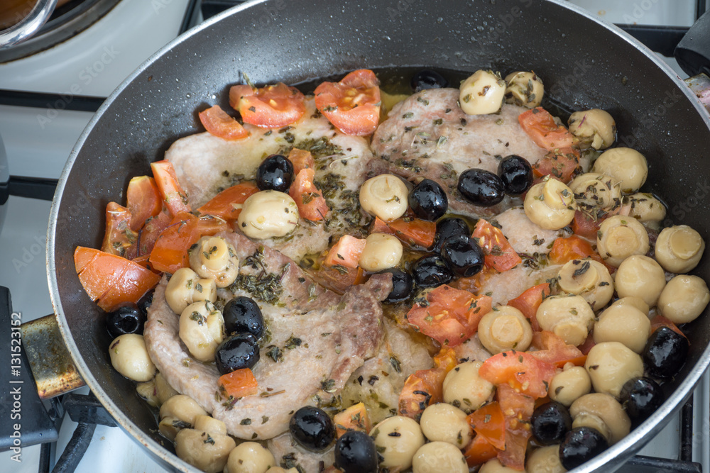 pork steak in the pan with cherry tomatoes black olives and mushrooms pork steak in the pan with cherry tomatoes black olives and mushrooms