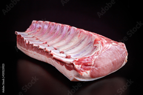 Photography Fresh Raw French whole rack of pork loin with ribs on black board