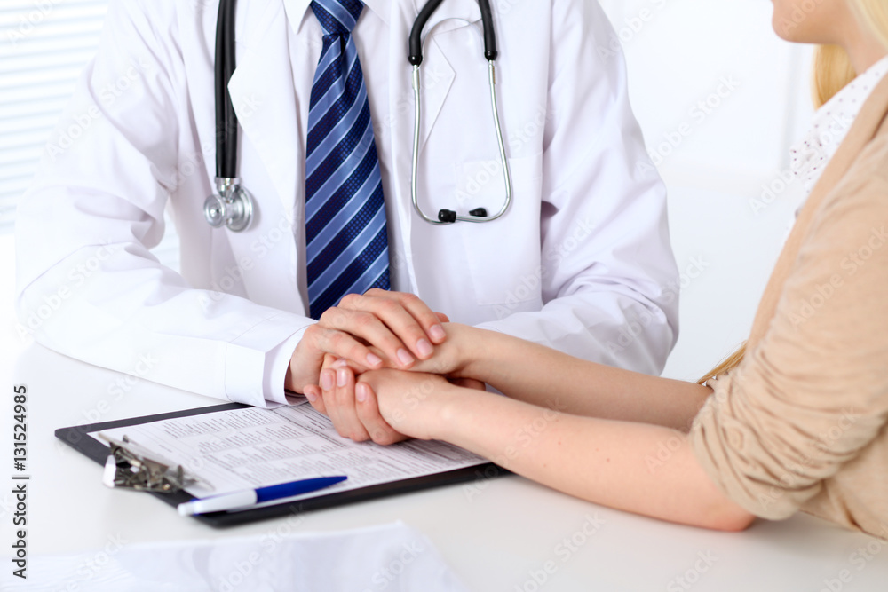 Hand of doctor reassuring her female patient. Medical ethics and trust concept Hand of doctor reassuring her female patient. Medical ethics and trust concept