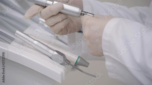Close-up of dentist's hands and dental equipment, young doctor checking equipmnet in modern hospital photo