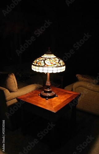 Silent evening.A colorful lampshade lights up a dark room. photo