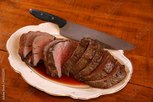 Slika na platnu Medium rare beef tenderloin on a platter waiting to be served.