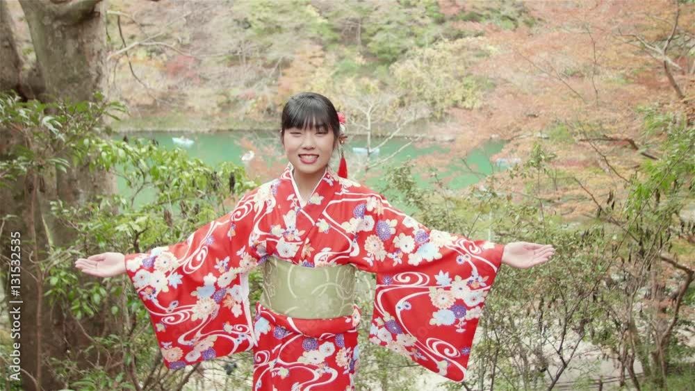Young Japanese women welcomes tourists to Kyoto in Red Kimono Young Japanese women welcomes tourists to Kyoto in Red Kimono