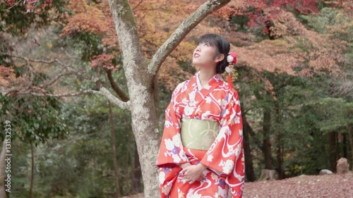 Japanese girl red kimono walking through Kyoto forest