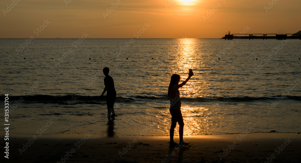 Fototapeta premium People walk ocean beach sunset